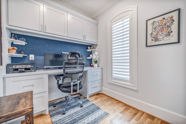 7119 Janet St, Houston, TX 77055 - home office with built in desk, ornamental molding, light wood-style flooring, and baseboards