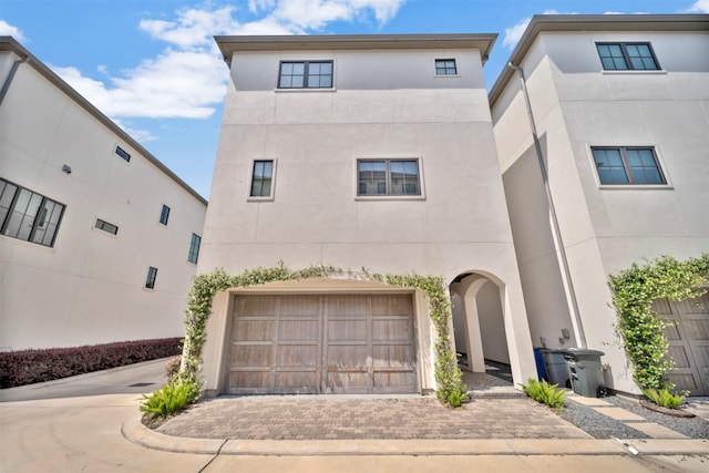 7119 Janet St, Houston, TX 77055 - view of front facade featuring stucco siding, an attached garage, and decorative driveway