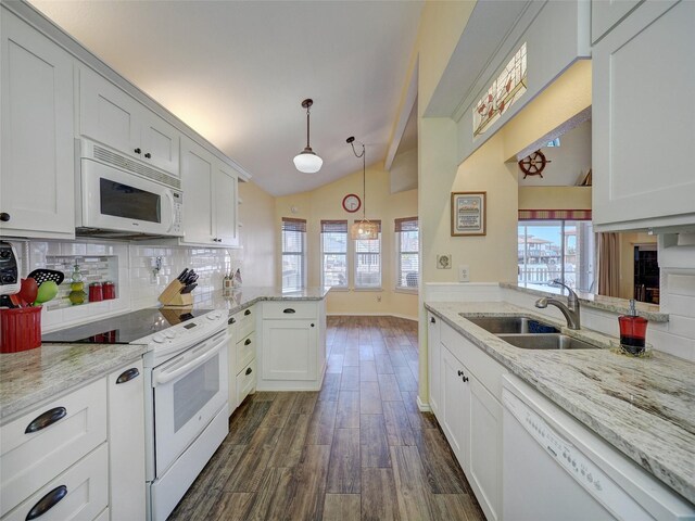 13558 Peseta Ct, Corpus Christi, TX 78418 - kitchen with white appliances, a sink, a peninsula, dark wood finished floors, and vaulted ceiling