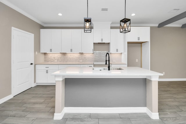 8103 Venus Dr, Houston, TX 77088 - kitchen featuring a sink, a kitchen island with sink, baseboards, decorative backsplash, and light countertops