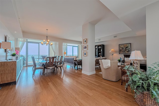 801 E Beach Dr Unit Tw2008, Galveston, TX 77550 - dining room featuring light wood-style floors, a chandelier, and baseboards