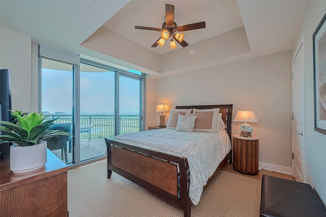 801 E Beach Dr Unit Tw2008, Galveston, TX 77550 - bedroom featuring access to outside, a tray ceiling, and a ceiling fan
