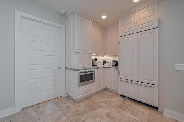 801 E Beach Dr Unit Tw2008, Galveston, TX 77550 - kitchen featuring paneled built in fridge, white cabinetry, backsplash, baseboards, and recessed lighting
