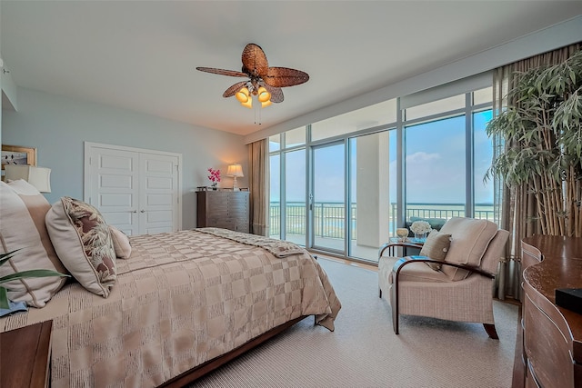 801 E Beach Dr Unit Tw2008, Galveston, TX 77550 - bedroom with access to outside, expansive windows, a water view, carpet floors, and a closet