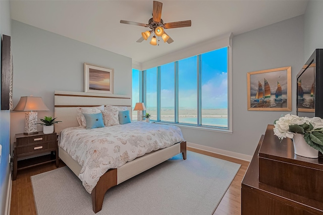 801 E Beach Dr Unit Tw2008, Galveston, TX 77550 - bedroom with wood finished floors, baseboards, and ceiling fan