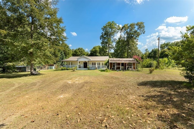 back of house featuring a yard and covered porch