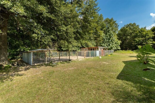 view of green lawn featuring exterior structure and an outbuilding
