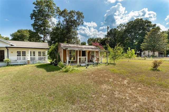 rear view of house featuring a yard and covered porch