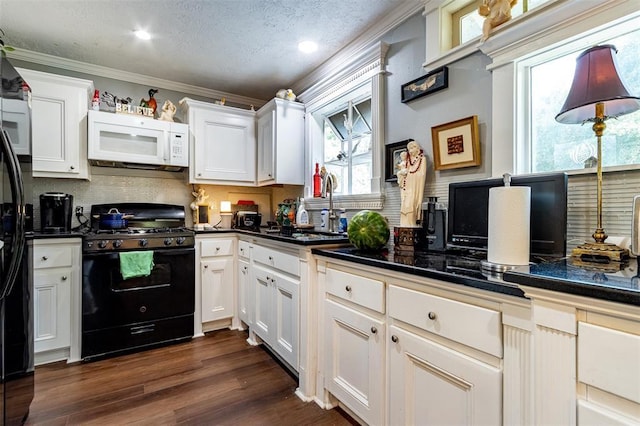 kitchen with black appliances, dark countertops, decorative backsplash, a sink, and white cabinets