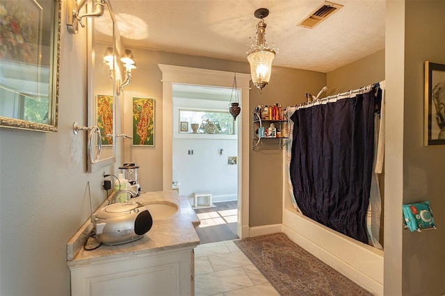 bathroom featuring vanity, a textured ceiling, and marble finish flooring