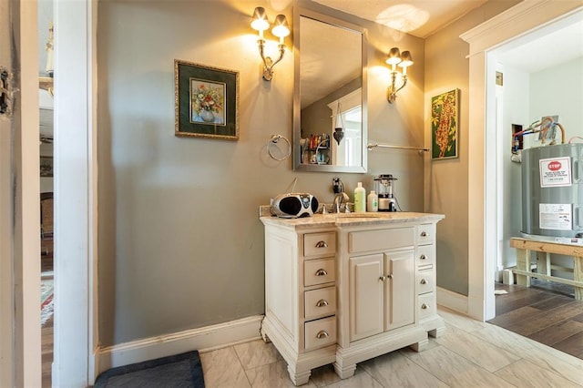 bathroom featuring baseboards, vanity, water heater, and marble look tiles