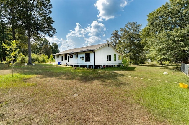 rear view of house featuring a yard