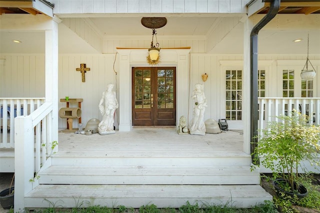 view of exterior entry with french doors and a porch