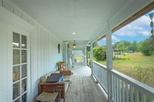 wooden terrace with a porch and a yard
