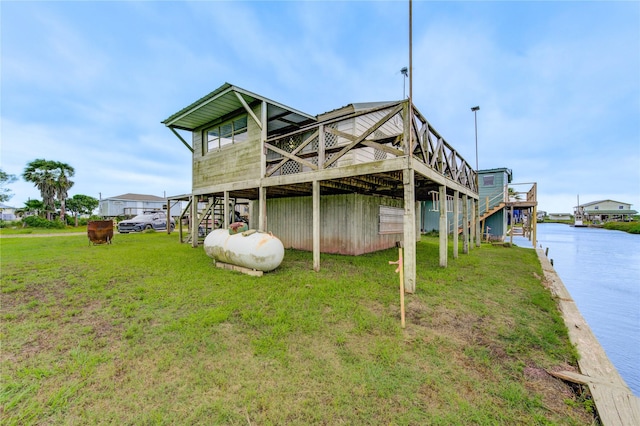 1577 Channel Dr, Brazoria, TX 77422 - rear view of house featuring stairway, a lawn, and a deck with water view