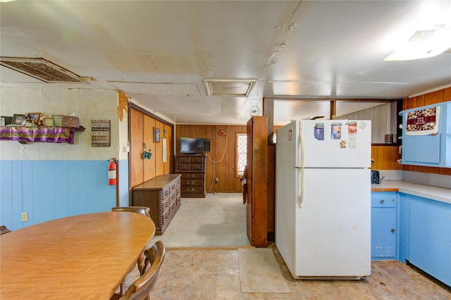 1577 Channel Dr, Brazoria, TX 77422 - kitchen featuring freestanding refrigerator, wood walls, and light countertops