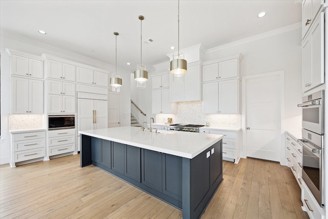 kitchen with white cabinetry, light countertops, decorative backsplash, crown molding, and light wood finished floors