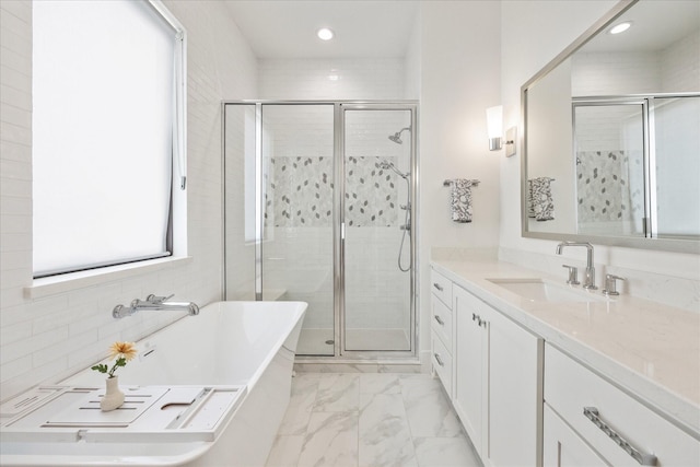 full bathroom with a shower stall, marble finish flooring, vanity, a soaking tub, and recessed lighting