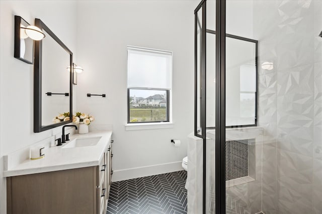 bathroom with a stall shower, baseboards, vanity, and toilet