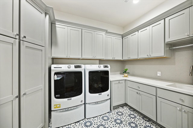 washroom featuring washer and clothes dryer and cabinet space