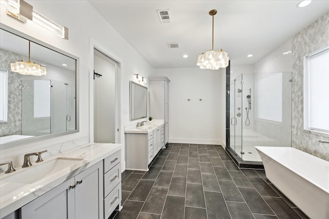 full bathroom featuring a chandelier, plenty of natural light, a shower stall, a soaking tub, and recessed lighting