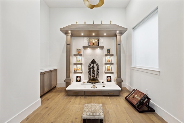 detailed view of ornate columns, wood finished floors, and baseboards