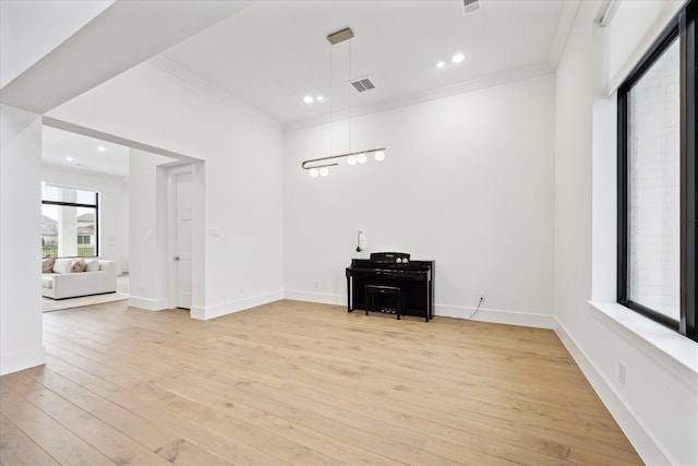 living area featuring light wood finished floors, crown molding, recessed lighting, and baseboards