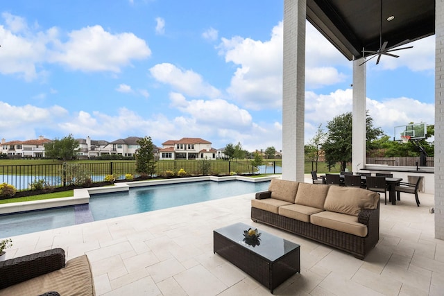 view of swimming pool with outdoor lounge area, a fenced backyard, a patio, a water view, and a residential view