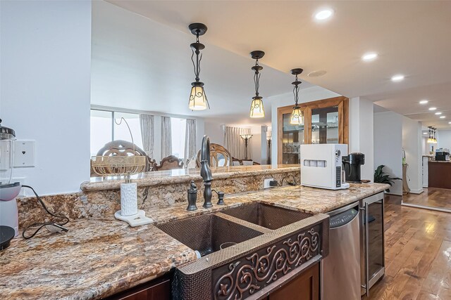 kitchen featuring stainless steel dishwasher, wood-type flooring, recessed lighting, light stone counters, and pendant lighting