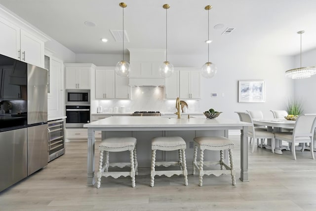 26923 Arethusa Ct, Spring, TX 77389 - kitchen featuring wine cooler, stainless steel appliances, a kitchen bar, backsplash, and recessed lighting