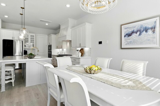 dining room featuring light wood-style flooring, a chandelier, and recessed lighting