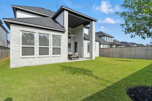 rear view of property with a patio area, roof with shingles, and brick siding