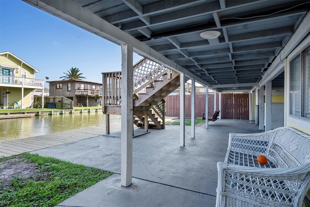 11 Highland Dr, Hitchcock, TX 77563 - view of patio / terrace featuring stairs, fence, a boat dock, and a water view