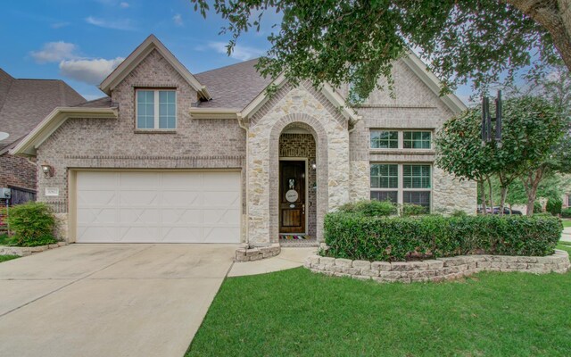 view of front of property featuring concrete driveway, brick siding, a front lawn, and roof with shingles