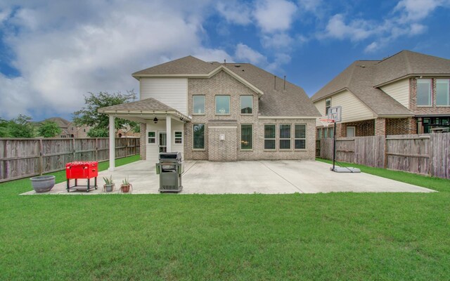 rear view of house with a patio, brick siding, and roof with shingles