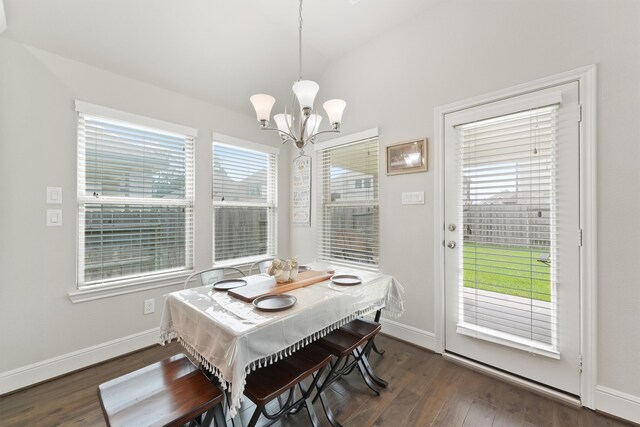 dining room featuring a chandelier, dark wood-style floors, baseboards, and lofted ceiling