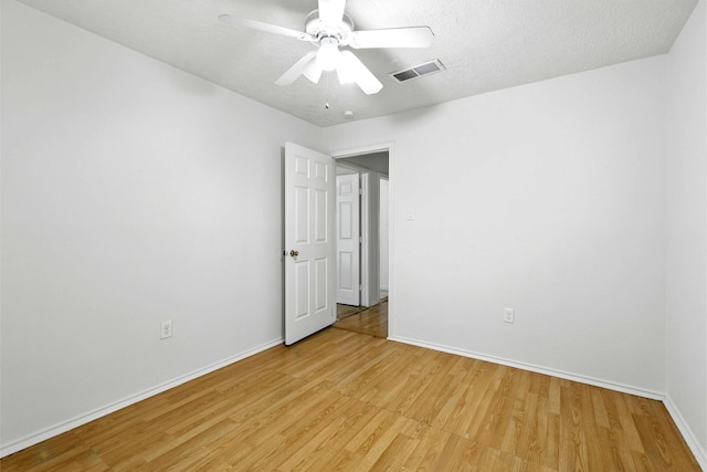 24011 Lone Elm Dr, Spring, TX 77373 - unfurnished room featuring light wood-style flooring, baseboards, ceiling fan, and a textured ceiling
