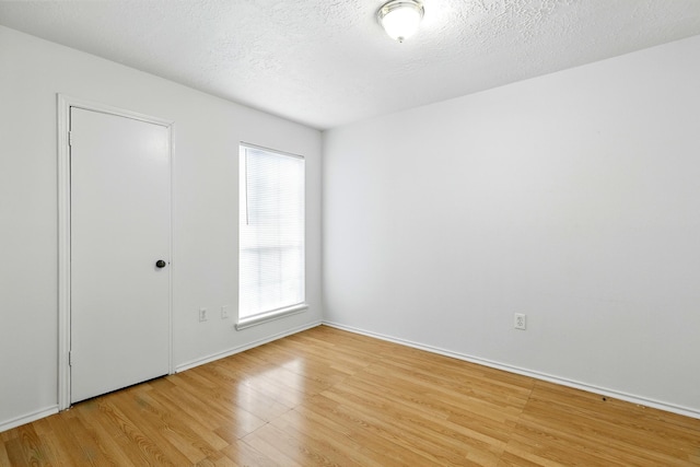 24011 Lone Elm Dr, Spring, TX 77373 - empty room featuring light wood-type flooring, baseboards, and a textured ceiling