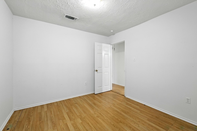 24011 Lone Elm Dr, Spring, TX 77373 - spare room featuring light wood-type flooring, baseboards, and a textured ceiling
