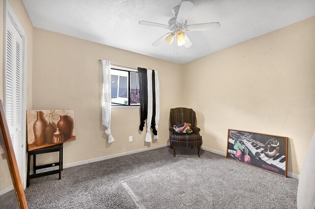 living area with carpet, ceiling fan, and baseboards