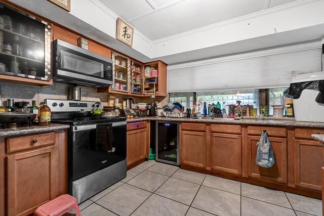 kitchen with appliances with stainless steel finishes, wine cooler, crown molding, brown cabinetry, and light tile patterned floors