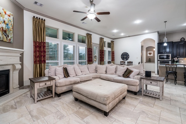 22903 Laburname Ct, Tomball, TX 77375 - living area featuring arched walkways, crown molding, a ceiling fan, a fireplace, and recessed lighting