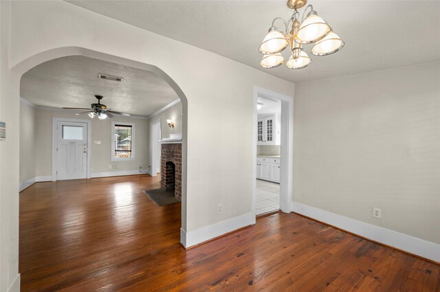 unfurnished living room featuring arched walkways, wood-type flooring, and ceiling fan