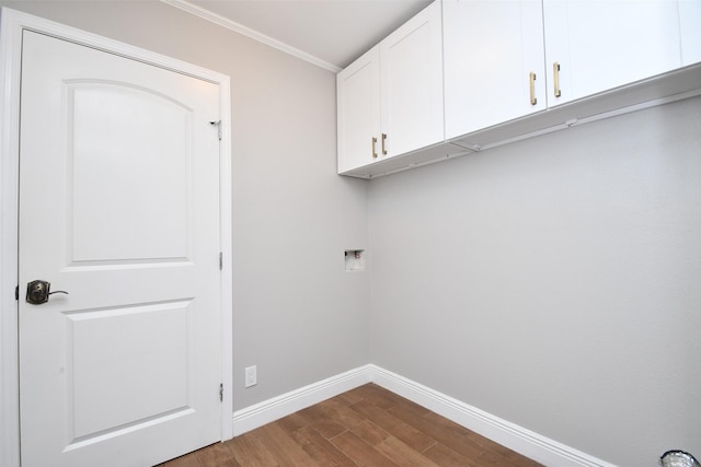 laundry room featuring cabinet space, baseboards, dark wood-type flooring, ornamental molding, and hookup for a washing machine