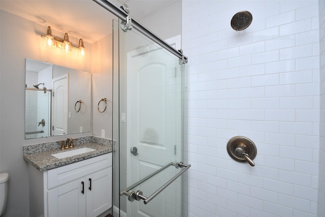bathroom featuring a stall shower, vanity, and toilet