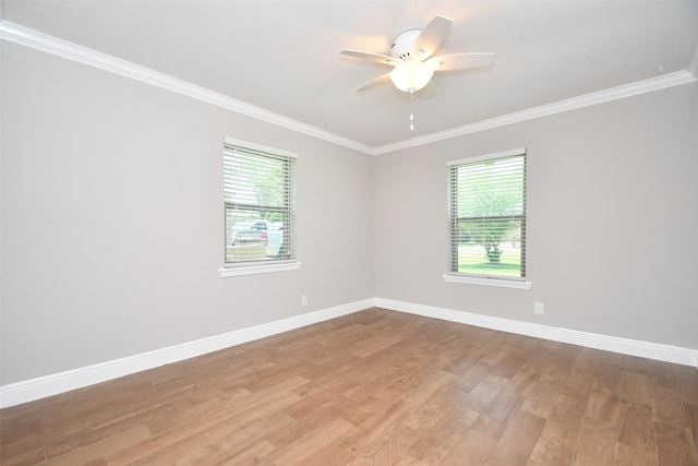 spare room with ornamental molding, plenty of natural light, light wood-style floors, baseboards, and ceiling fan