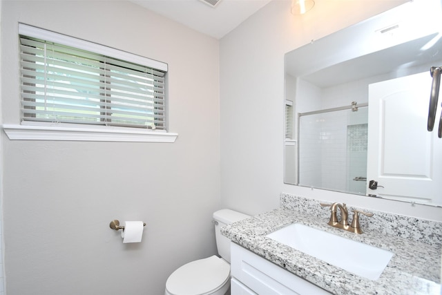 full bathroom with toilet, tiled shower, and vanity