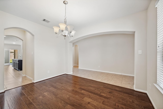 18230 Russett Green Dr, Tomball, TX 77377 - unfurnished room featuring wood finished floors, a chandelier, arched walkways, and baseboards