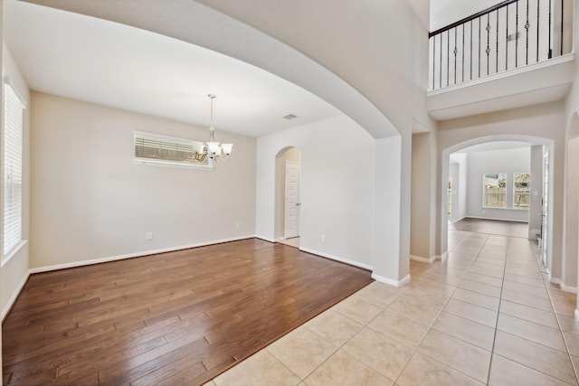 18230 Russett Green Dr, Tomball, TX 77377 - entryway featuring light wood-style floors, healthy amount of natural light, a chandelier, and arched walkways