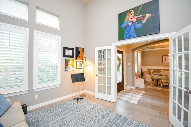 5006 Isidore Ln, Missouri City, TX 77459 - living area featuring french doors, a towering ceiling, arched walkways, and baseboards